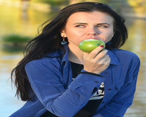 Lifestyle shot of a woman eating healthy fruit salad outdoors